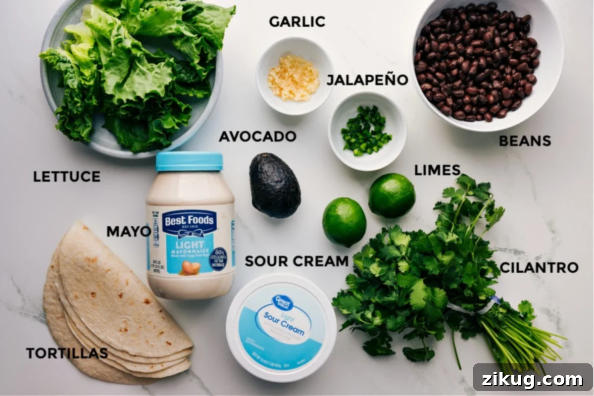 Ingredients In Black Bean Wraps All the ingredients for this recipe prepped and ready for easy assembly, including lettuce, avocado, limes, beans, sour cream, mayo, cilantro, and tortillas.