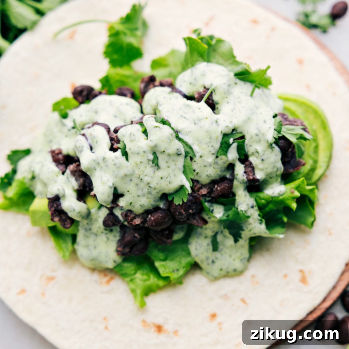 How To Make Black Bean Wraps A black bean wrap, opened up to reveal the delicious filling of avocado, lettuce, black beans, and the most flavorful cilantro lime sauce.