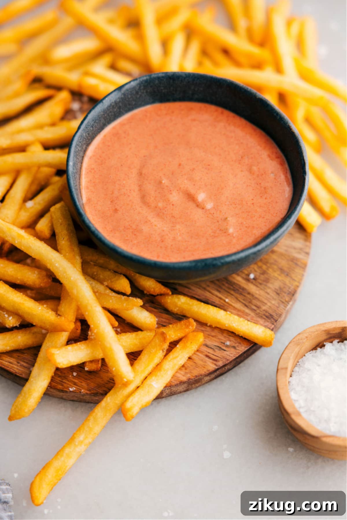 An enticing bowl of the best homemade fry sauce, perfectly creamy and textured, with a generous serving of golden, crisp french fries artistically arranged beside it, ready for a delightful dip.