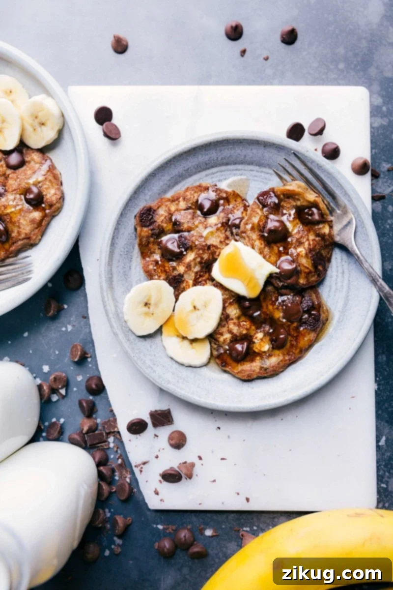Irresistible Gluten-Free Banana Pancakes with Chocolate Chips and Banana Toppings Delicious stack of gluten-free banana pancakes with melted chocolate chips, garnished with fresh banana slices and a light dusting of powdered sugar, ready for a healthy breakfast.