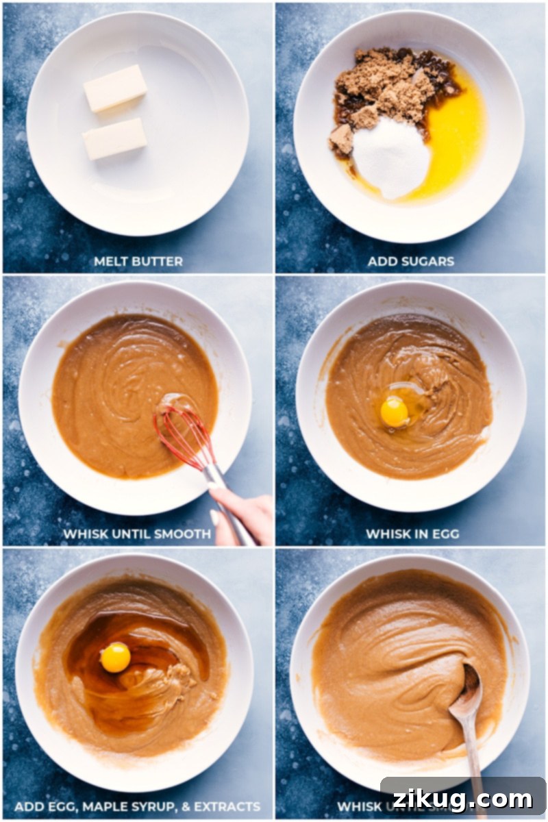 A bowl of wet ingredients for maple cookies, including melted butter, sugars, eggs, and extracts, being whisked together.