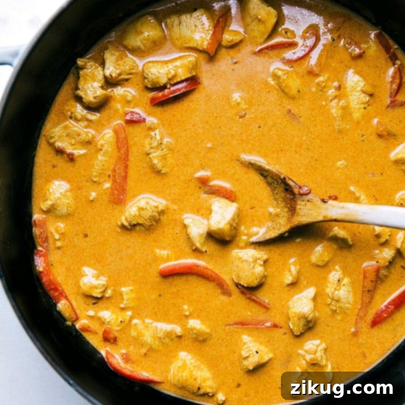 The flavorful meal cooking in the pan, rich with sauce and aromatic spices.