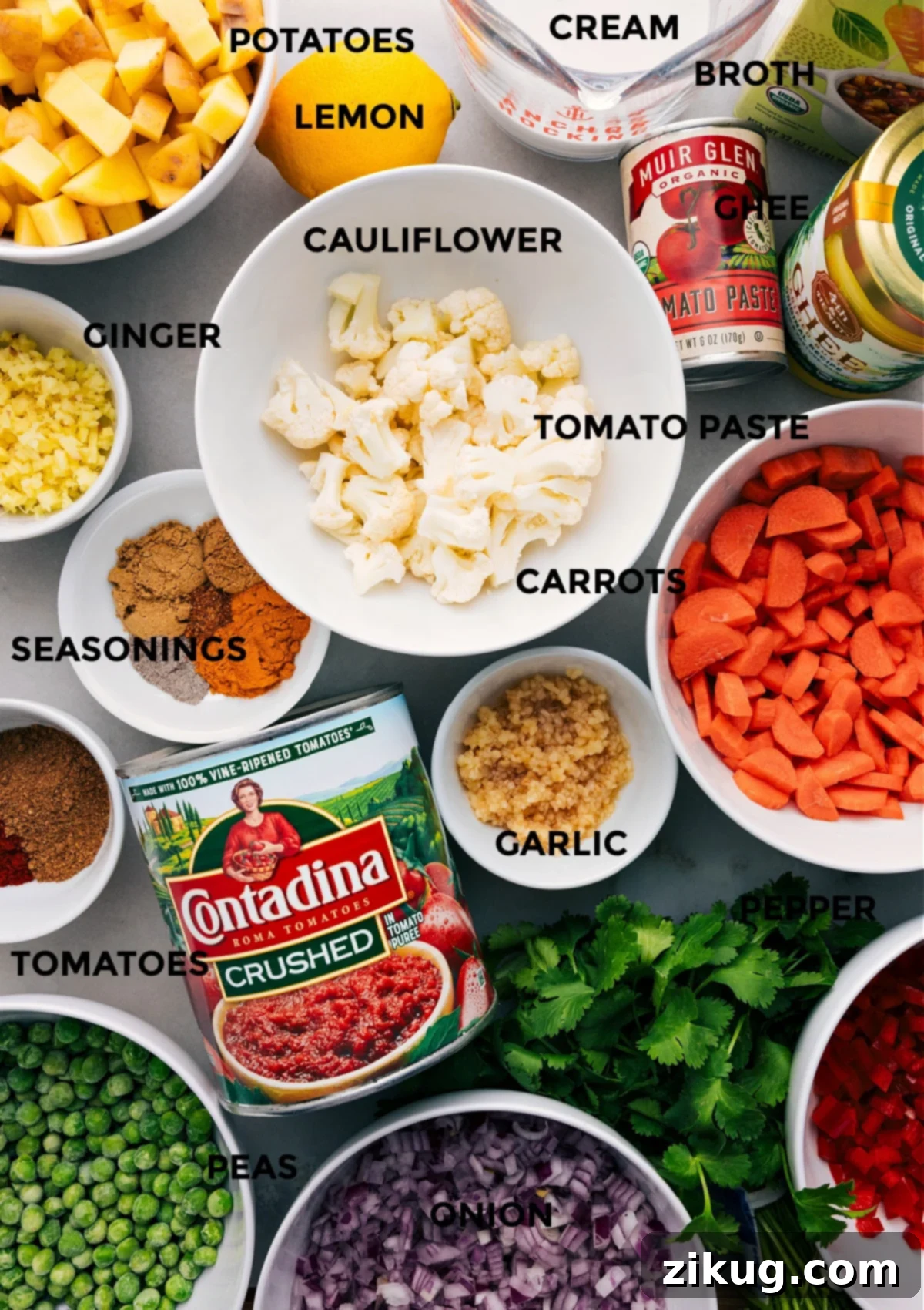 Key Ingredients For Vegetable Masala All the fresh ingredients neatly prepped on a wooden board, including diced vegetables, a vibrant array of spices, canned tomatoes, ghee, tomato paste, vegetable broth, heavy cream, and a fresh lemon, ready for assembling the vegetable masala.