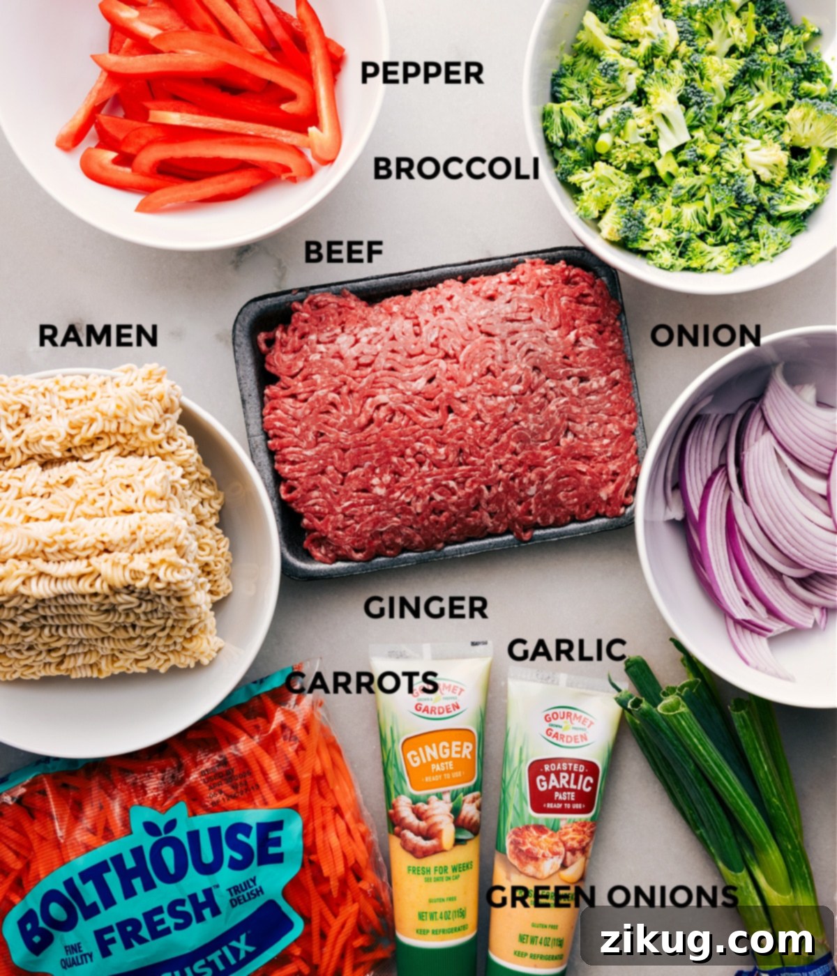 All the ingredients for this recipe are prepped and ready to go—peppers, broccoli, meat, onion, noodles, ginger, garlic, green onions, and carrots.