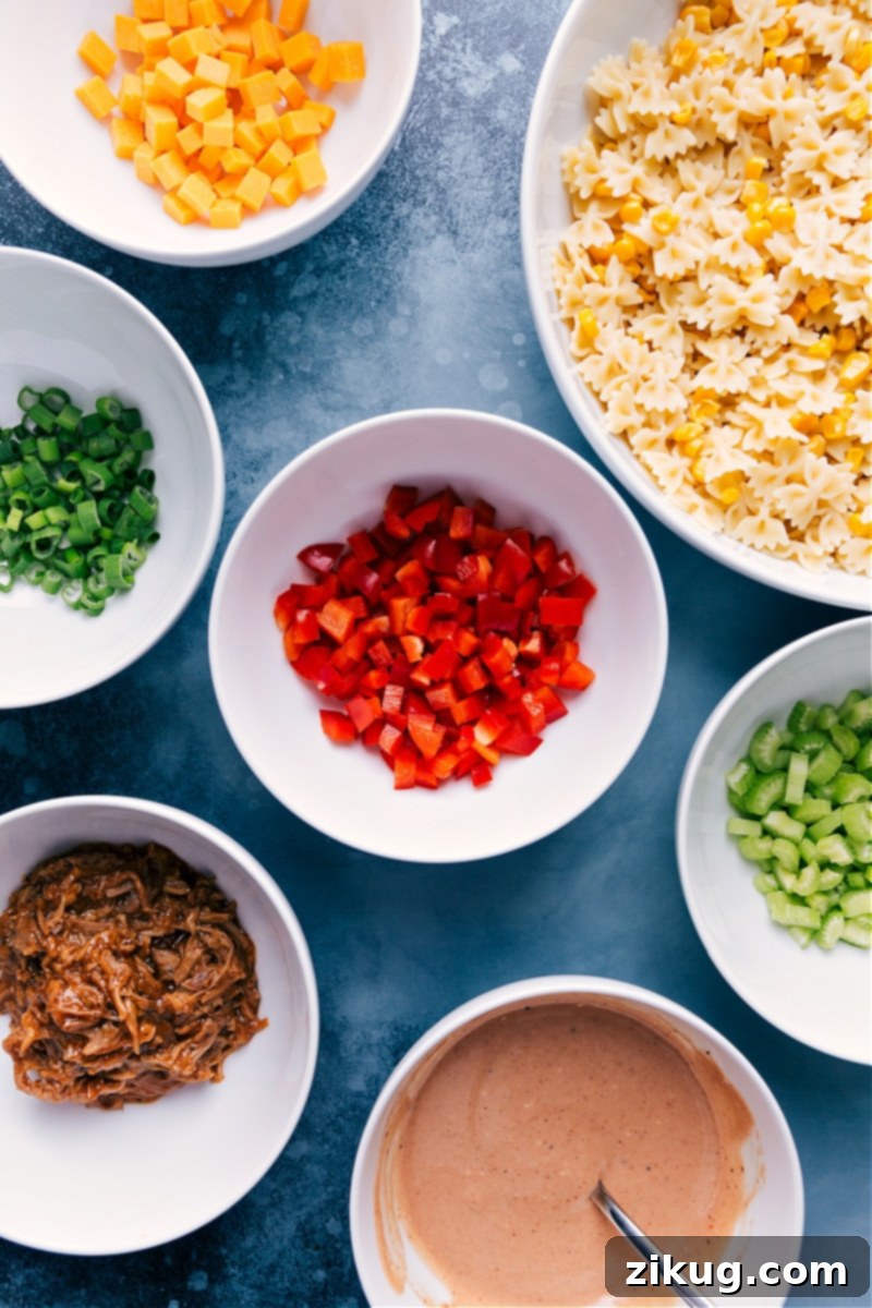 Ingredients In BBQ Pasta Salad Prepped Out Ingredients prepped out for this recipe prepped out for easy assembly including the cheese, pasta, peppers, green onions, celery, pork, and sauce.