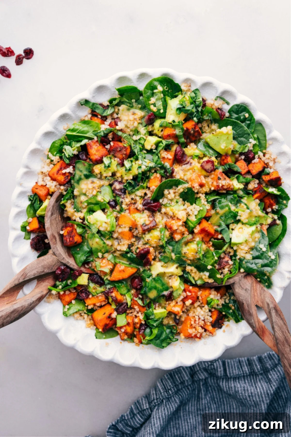 Delicious and Healthy Sweet Potato Quinoa Salad Recipe Vibrant Sweet Potato Quinoa Salad with beautifully roasted sweet potatoes, fluffy quinoa, fresh spinach, juicy cranberries, and creamy avocado, all elegantly arranged in a rustic bowl and drizzled with a bright lemon dressing, ready for a healthy and satisfying meal.