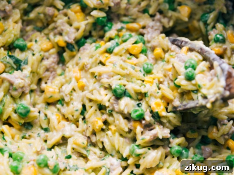 The best ever 30-minute Creamy Pesto Orzo! Recipe via ChelseasMessyApron #dinner #quick #easy #simple #best #peas #corn #comfortfood #kidfriendly #creamy #pesto #orzo Close-up view of Creamy Pesto Orzo