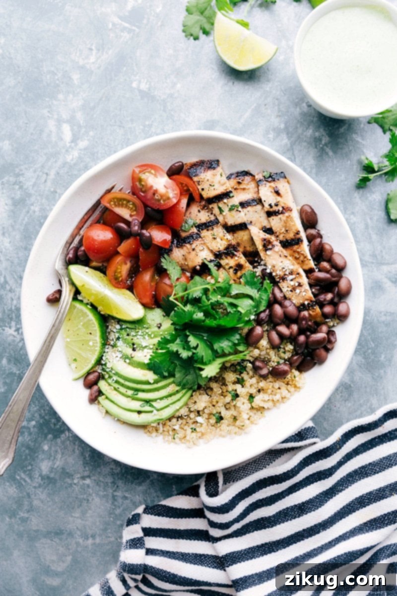 Honey-Lime Chicken Bowl with Quinoa, Tomatoes, Avocados, and Black Beans A bowl filled with honey-lime chicken served with quinoa, tomatoes, avocados, and black beans, creating a flavorful and wholesome meal.
