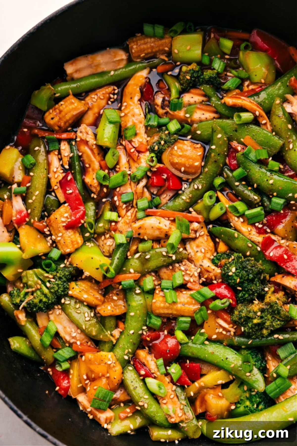 30-Minute One Skillet Rotisserie Chicken Stir Fry The finished Rotisserie Chicken Stir-Fry, glistening with its savory sauce, presented in a large skillet, ready for serving.