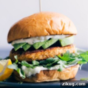 Close-up of a homemade Salmon Burger patty, showcasing its golden-brown crust and juicy texture, ready to be assembled on a bun.
