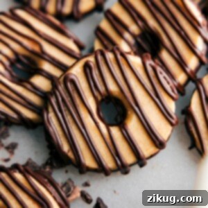 Homemade Fudge-Striped Cookies on a cooling rack, freshly baked and partially dipped in chocolate.