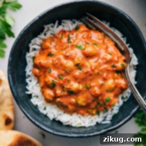 A bowl of creamy Butter Chickpeas garnished with fresh herbs.