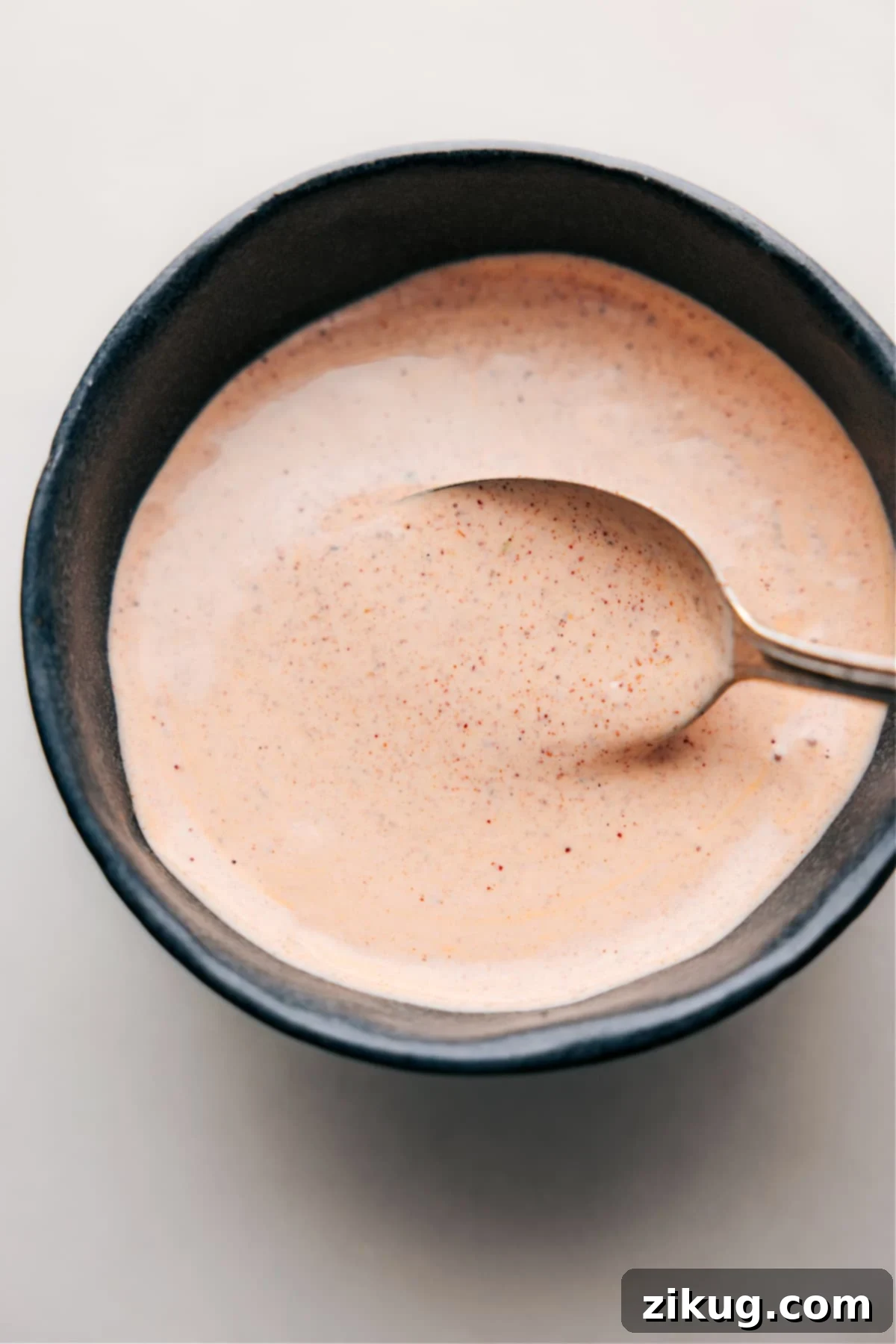 Zesty Fish Taco Sauce: A Creamy Delight Ready to Transform Your Seafood Dishes! A bowl of creamy, zesty fish taco sauce with a spoon resting inside, ready to be served.