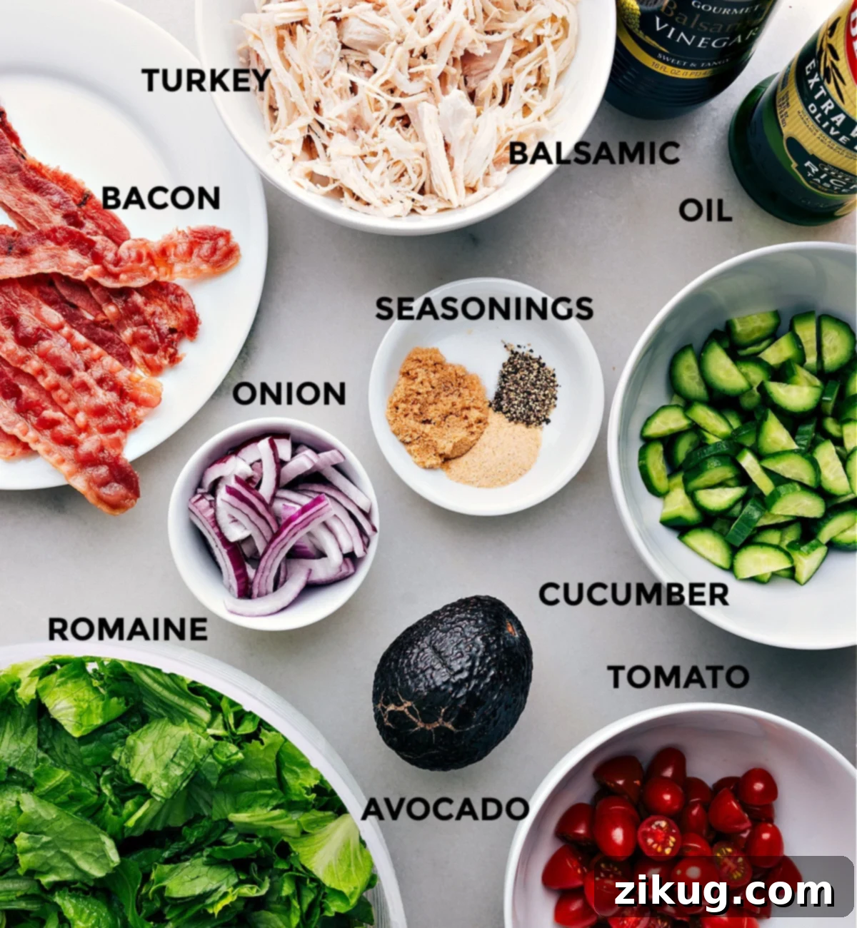 Ingredients In Turkey Bacon Avocado Salad A beautiful spread of fresh ingredients for Turkey Bacon Avocado Salad, including crisp romaine, colorful tomatoes, ripe avocado, and sliced red onion, all laid out and ready for preparation.