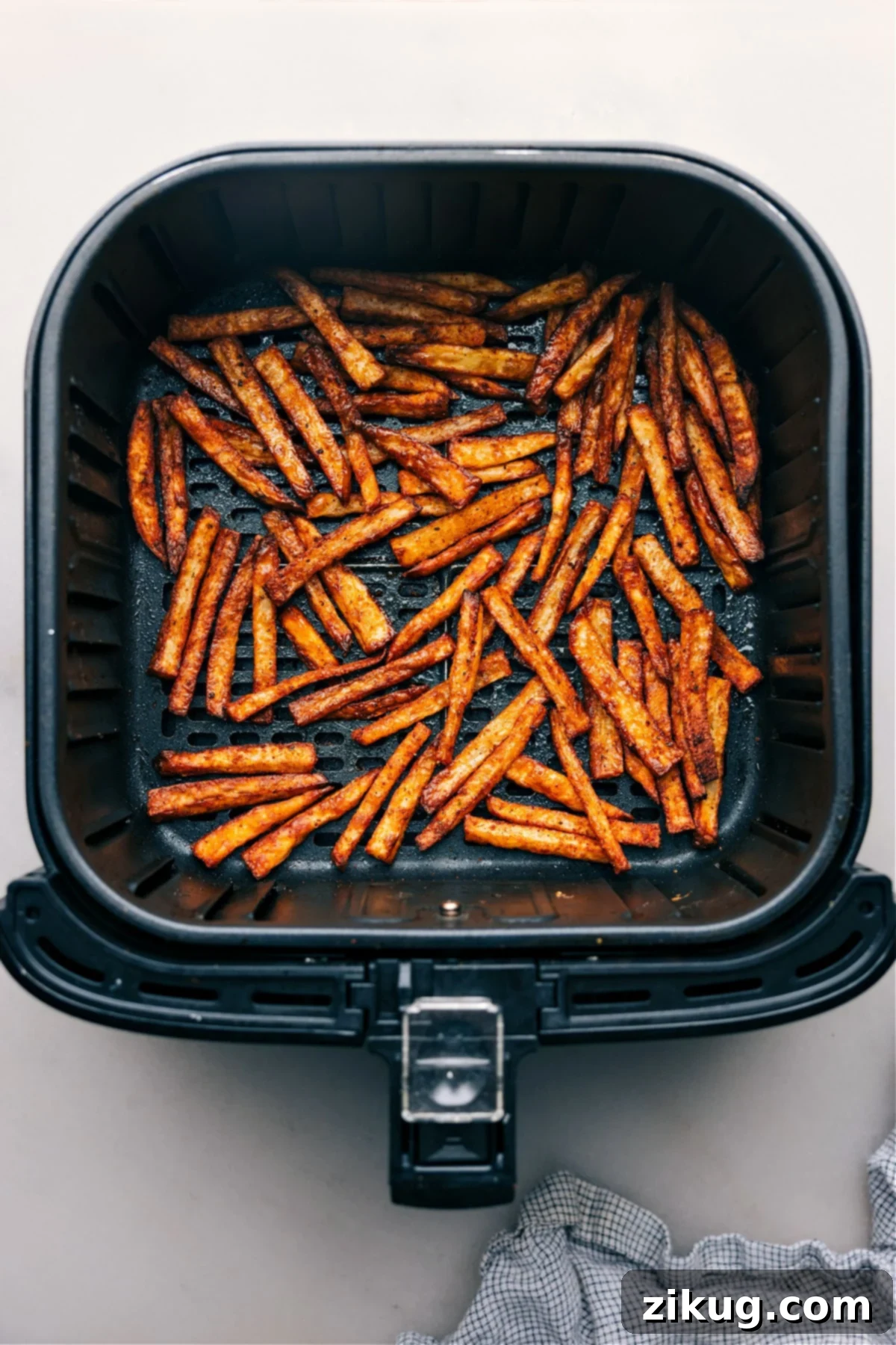 Life-Changing Air Fryer Potatoes A basket of freshly cooked Air Fryer Fries, golden and perfectly crispy, just removed from the air fryer.