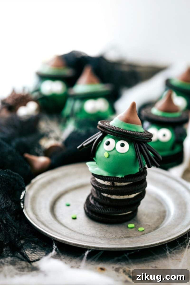 Spooktacular Oreo Truffles 7 A green witch Oreo ball adorned with black licorice hair, an Oreo hat with a Hershey's Kiss, and edible eyes, perfect for a magical Halloween.