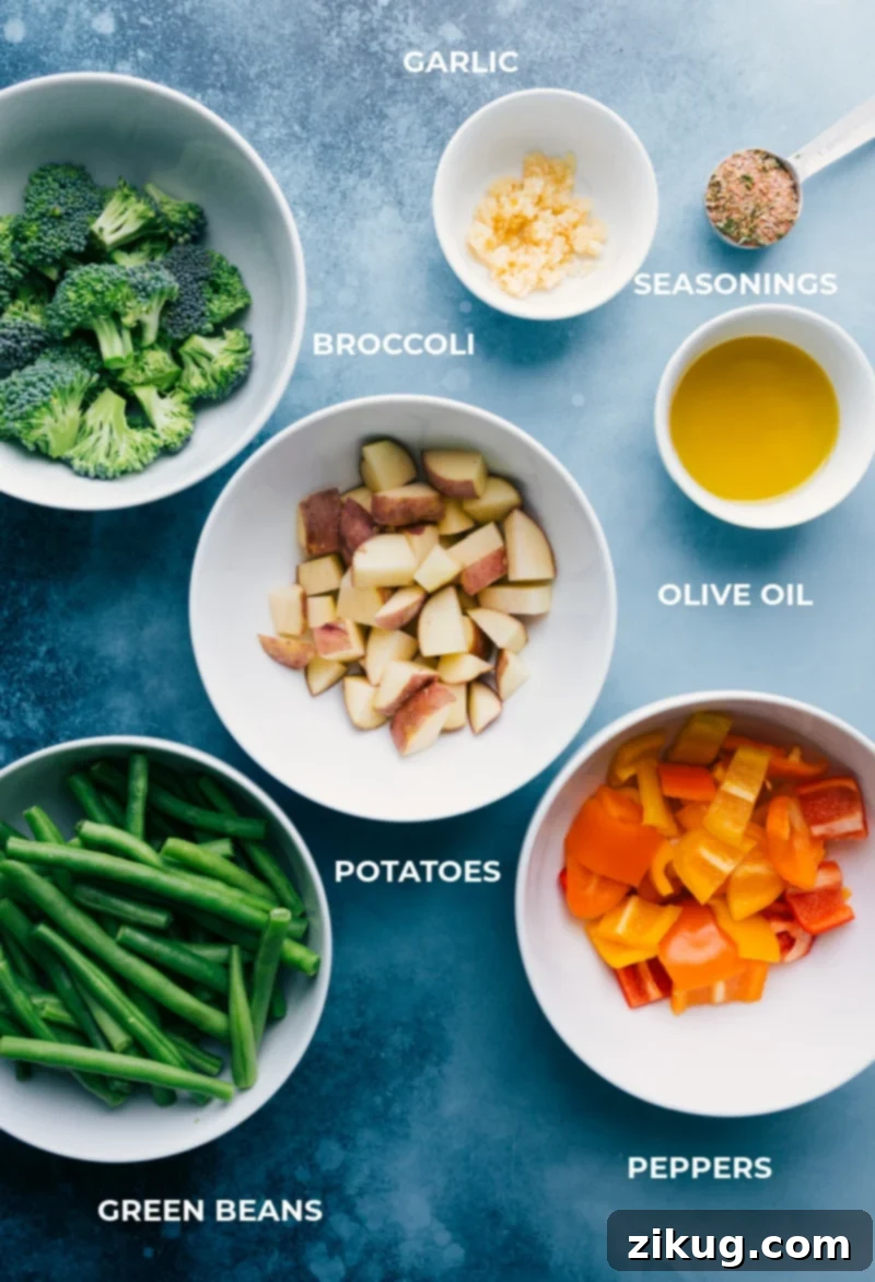 Fresh Ingredients For Your Crispy Baked Parmesan Chicken Tenders Dinner A colorful array of fresh, prepped ingredients for Baked Parmesan Chicken Tenders and roasted veggies, including broccoli florets, diced red potatoes, bell peppers, green beans, garlic, olive oil, and a bowl of seasoning mix.