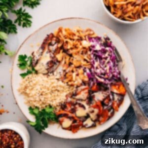 A beautifully presented Hot Honey Chicken Bowl with crispy fried onions and a generous drizzle of hot honey sauce.