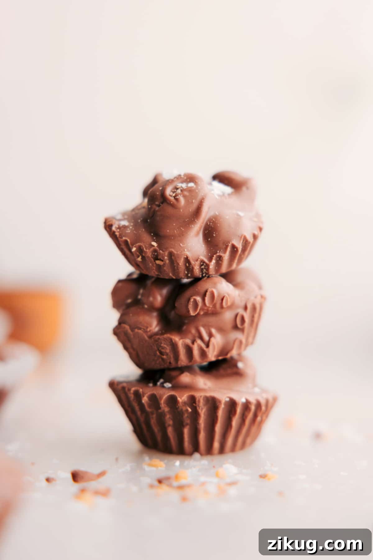 Stacked Crockpot Candy clusters, showcasing their rich chocolate coating and crunchy peanut texture.