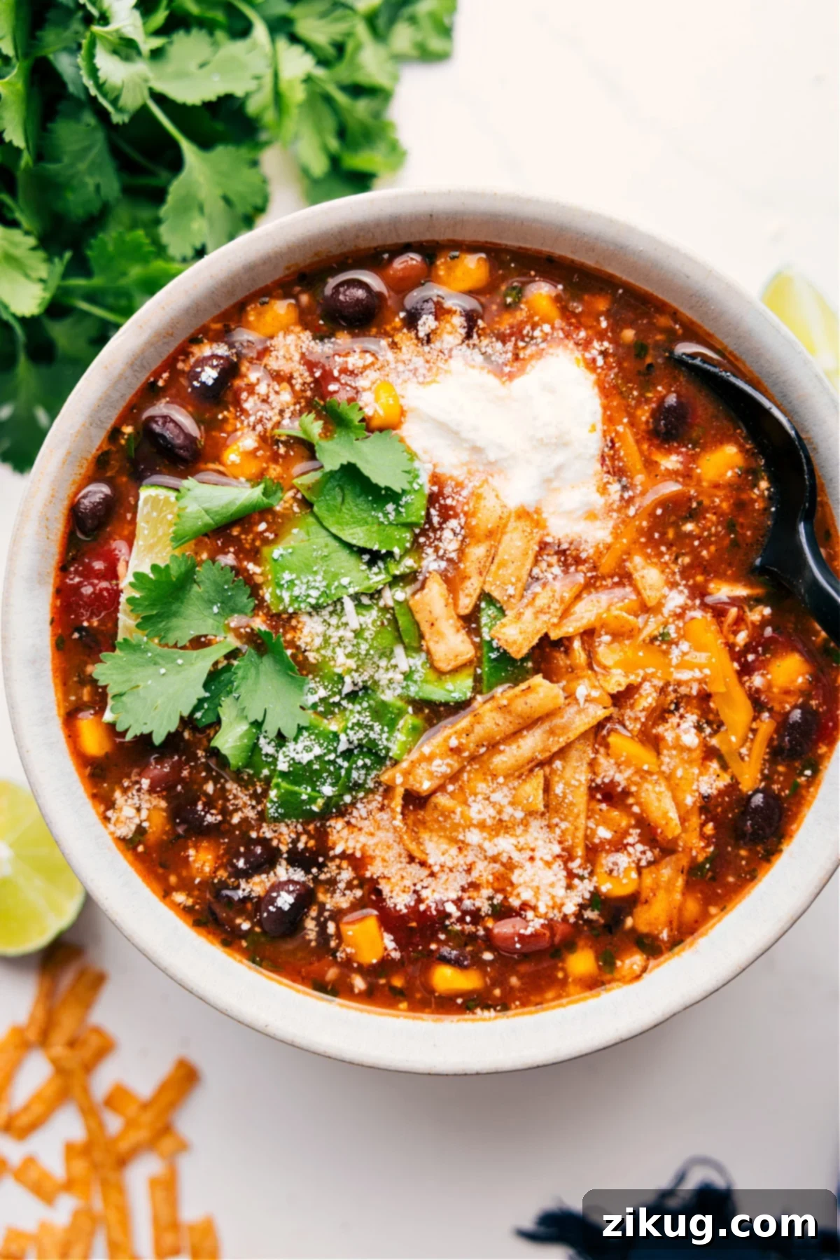 The Ultimate Chicken Taco Soup with Irresistible Toppings A steaming bowl of Chicken Taco Soup, generously topped with fresh cilantro, crispy tortilla strips, a dollop of sour cream, and shredded cheese, ready to be devoured.