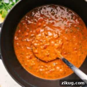 A beautifully presented bowl of Mediterranean Lentil Soup, garnished with fresh herbs and a drizzle of olive oil.