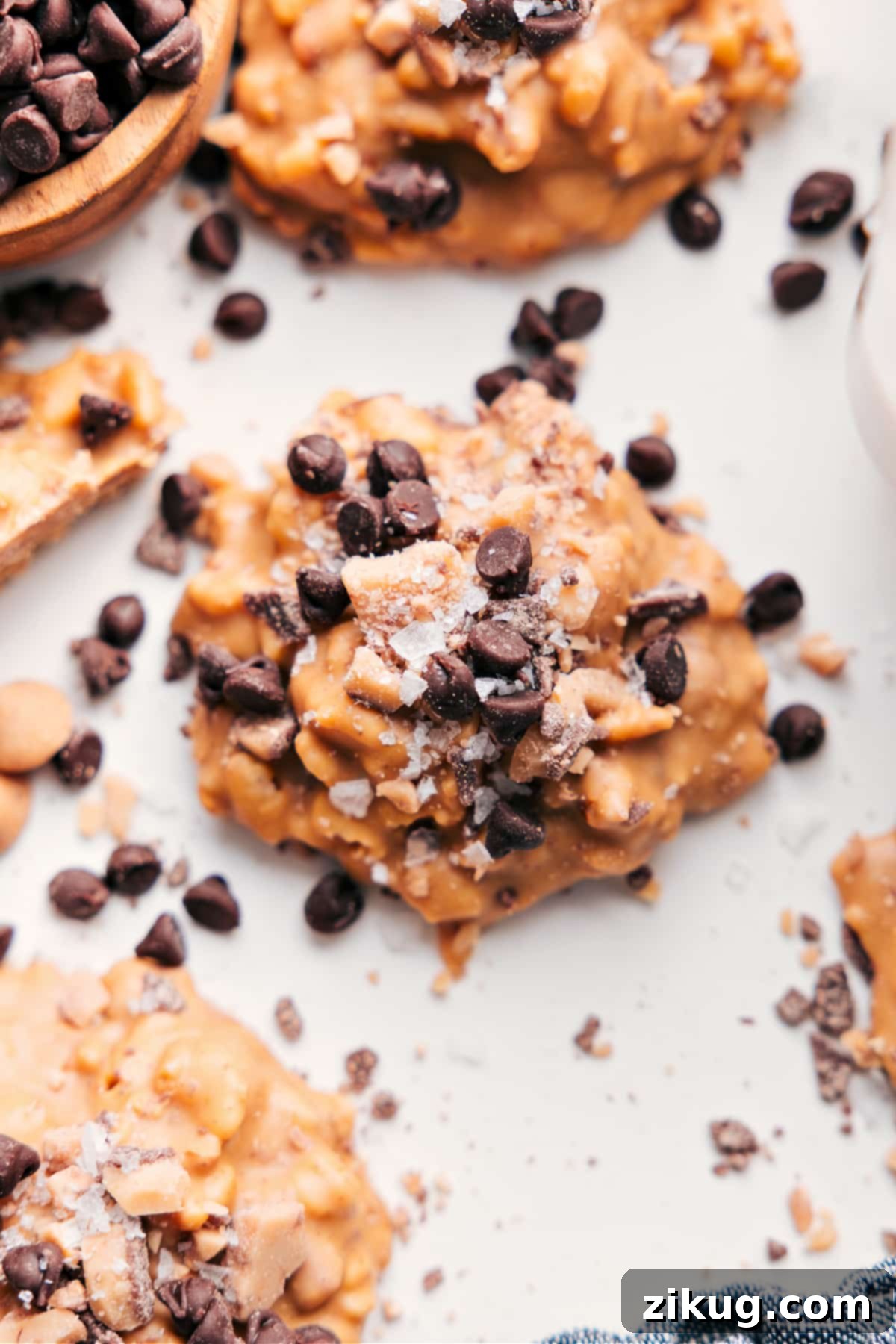 The Yummiest No-Bake Treat: White Chocolate Pretzel Clusters Delicious White Chocolate Pretzel Clusters topped with mini chocolate chips and flaky sea salt, arranged invitingly on parchment paper.