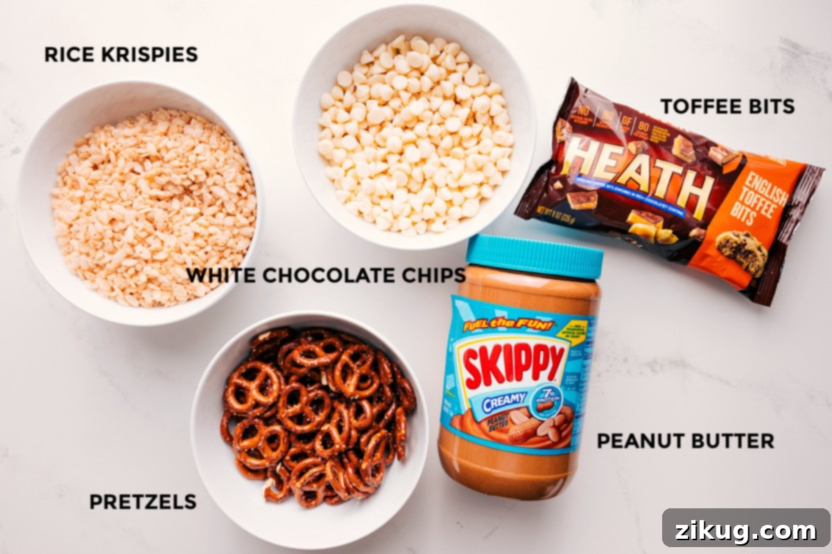 Ingredients In White Chocolate Pretzel Clusters All the essential ingredients for making White Chocolate Pretzel Clusters, including white chocolate chips, creamy peanut butter, Rice Krispies, crushed pretzels, and toffee bits, neatly arranged for preparation on a white surface.