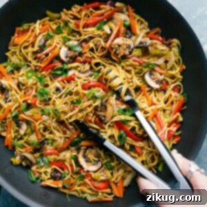 A vibrant bowl of freshly prepared vegetarian Chow Mein, ready to be served, showcasing a generous mix of colorful vegetables and glistening noodles coated in a rich, savory sauce.