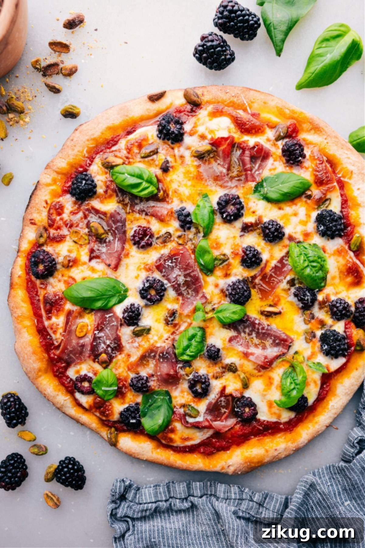 The Best Blackberry Basil Pizza Recipe Freshly baked Blackberry Basil Pizza, topped with vibrant fresh basil. A gourmet pizza with sweet and savory flavors, ready to be served.