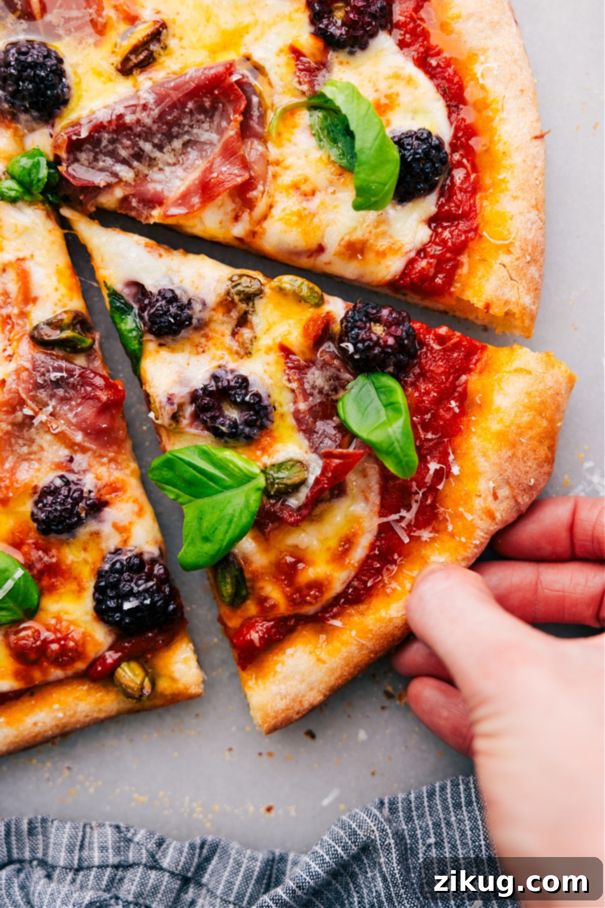 How To Make Blackberry Basil Pizza A slice of the delicious Blackberry Basil Pizza fresh out of the oven, showcasing the melted cheese, berries, and crispy crust. A perfect sweet and savory bite.