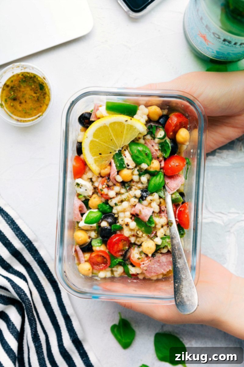 Delicious Italian Couscous Salad ready for serving, showcasing fresh ingredients and vibrant colors like cherry tomatoes, green bell pepper, olives, and mozzarella.