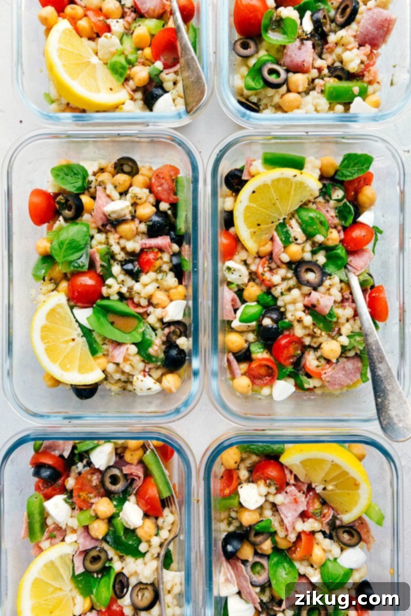 Close-up of freshly prepared Italian Couscous Salad, highlighting the colorful vegetables, savory salami, and creamy bocconcini mozzarella cheese, ready to be tossed.