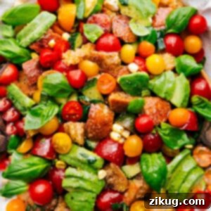 A vibrant, fresh Panzanella salad with golden bread cubes, red tomatoes, green basil, and white mozzarella.