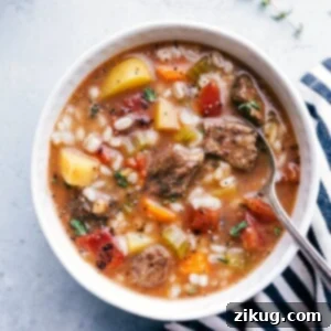 A delicious bowl of Easy Slow Cooker Beef and Barley Soup, garnished and ready to serve.