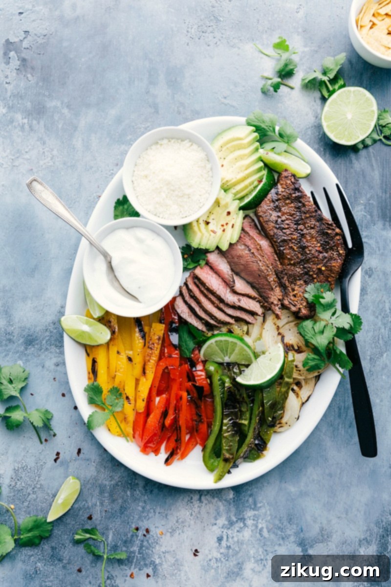 These Steak Fajitas are packed with juicy, flavorful marinated steak Plate of steak fajitas with bell peppers and onions, garnished with cilantro.