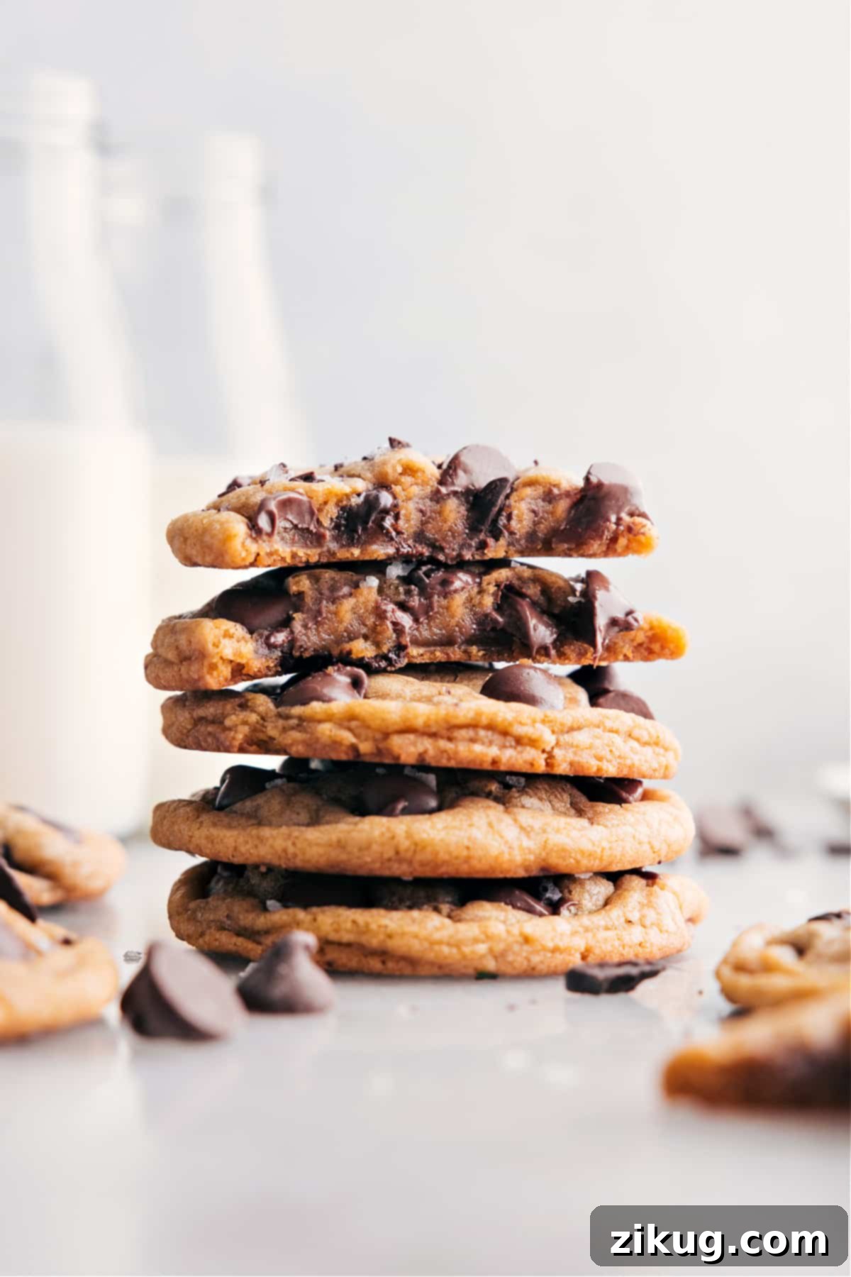 Perfectly Chewy Chocolate Chip Cookies 2 A stack of golden brown chewy chocolate chip cookies with melted chocolate chips visible, garnished with a few loose chocolate chips.