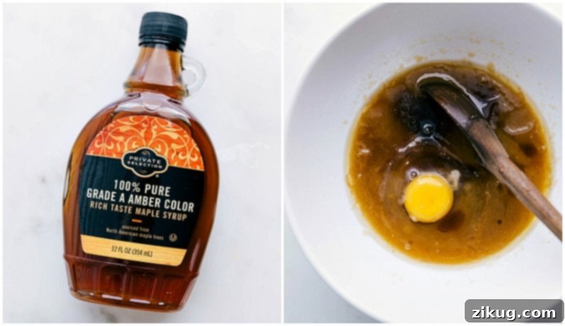Incorporating Maple Syrup and Egg into the Recipe Mixture A bottle of pure maple syrup and a cracked egg being added to the mixed butter and sugar bowl, highlighting key ingredients for the cookie recipe.