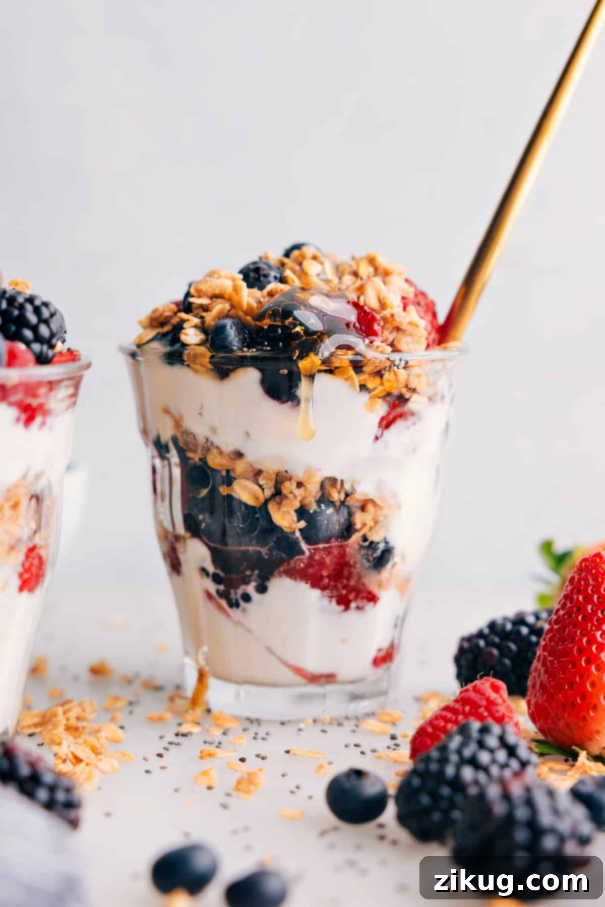 Layered Yogurt Parfait with Fresh Fruit and Granola Layered yogurt parfait in a clear glass cup, showcasing beautiful layers of creamy yogurt, vibrant fresh berries, a drizzle of golden honey, and crunchy granola on top. Ideal for a healthy and quick breakfast or snack.