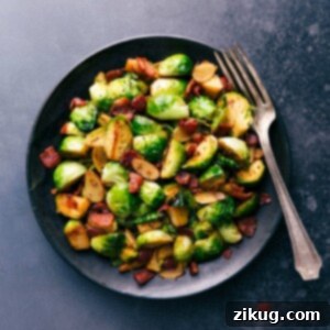 A close-up of sautéed Brussels sprouts and bacon on a plate, garnished and ready to be served.