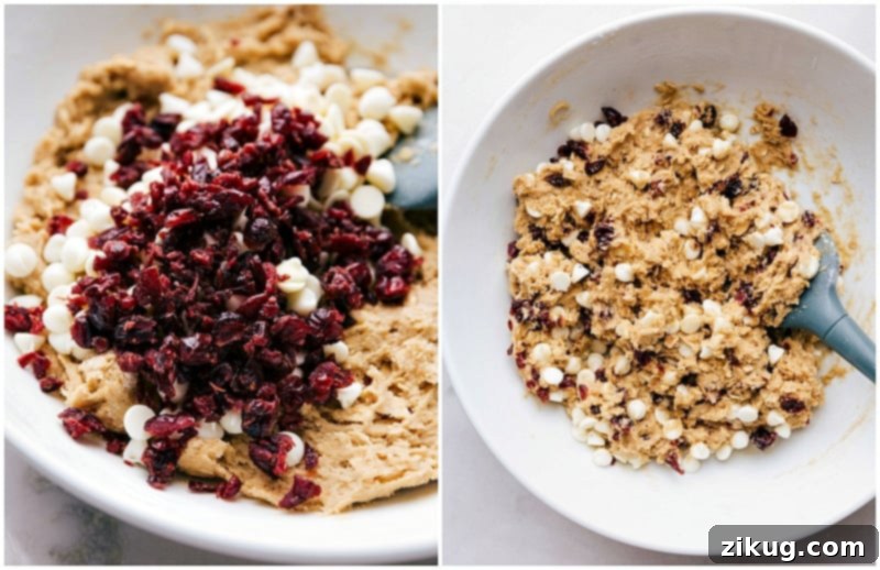 Final Touches to Cranberry Oatmeal Cookies: Adding Cranberries and White Chocolate Chips Stirring in cranberries and white chocolate chips into the cranberry oatmeal cookie dough for a final mix.