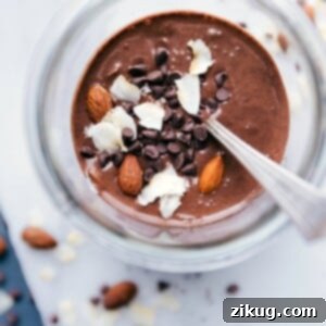 Almond joy overnight oats in a bowl, deliciously topped with almonds, shredded coconut, and chocolate chips.