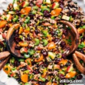 A close-up of the finished Cranberry Orange Wild Rice Pilaf, showcasing its rich textures and vibrant colors in a rustic serving bowl, garnished with fresh herbs.