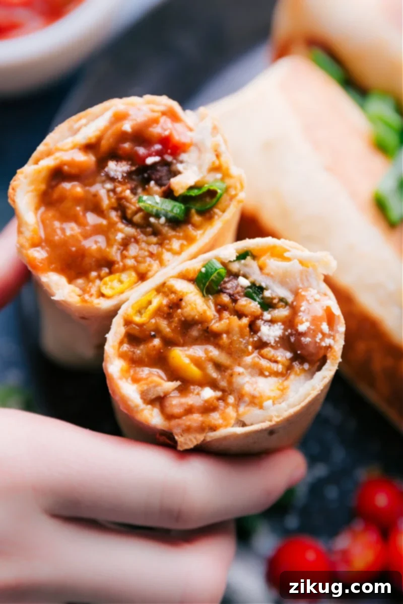 An enticing close-up of Bean and Cheese Burritos revealing their creamy pinto beans, Mexican-spiced rice, crisp corn, savory black beans, sour cream, and dual cheeses, all crisped to perfection in a skillet or air fryer for an ultimate vegetarian meal. #dinner #best #quick #easy #simple #vegetarian #avocado #tomato #salsa #bean #cheese #burritos Close-up overhead image of bean and cheese burritos, skillfully sliced in half to perfectly showcase the delicious, layered interior ingredients of beans, rice, and melted cheese.