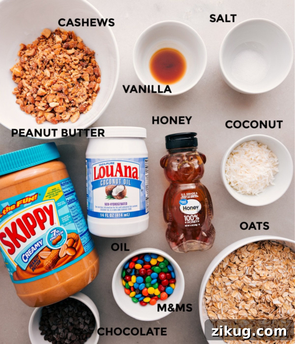 Essential Ingredients for the Best Chewy Granola Bars All essential ingredients for no-bake chewy granola bars displayed: oats, cashews, honey, peanut butter, coconut oil, vanilla, salt, shredded coconut, M&Ms, and chocolate chips.