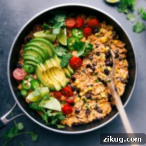 Sizzling Fiesta Chicken and Rice Skillet 3 Mexican chicken and rice in the skillet, topped with fresh vegetables ready to be mixed in, and all set to be enjoyed.