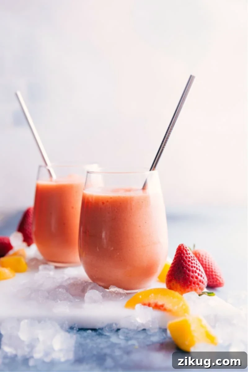 Discover the best Jamba Juice Caribbean Passion Smoothie copycat! Made with passion fruit juice, a blend of frozen strawberries, peaches, and mango, ice, and creamy orange sherbet. Perfect for breakfast, dessert, or a quick healthy treat. Two glasses of vibrant Caribbean Passion Smoothies, garnished and ready to enjoy.