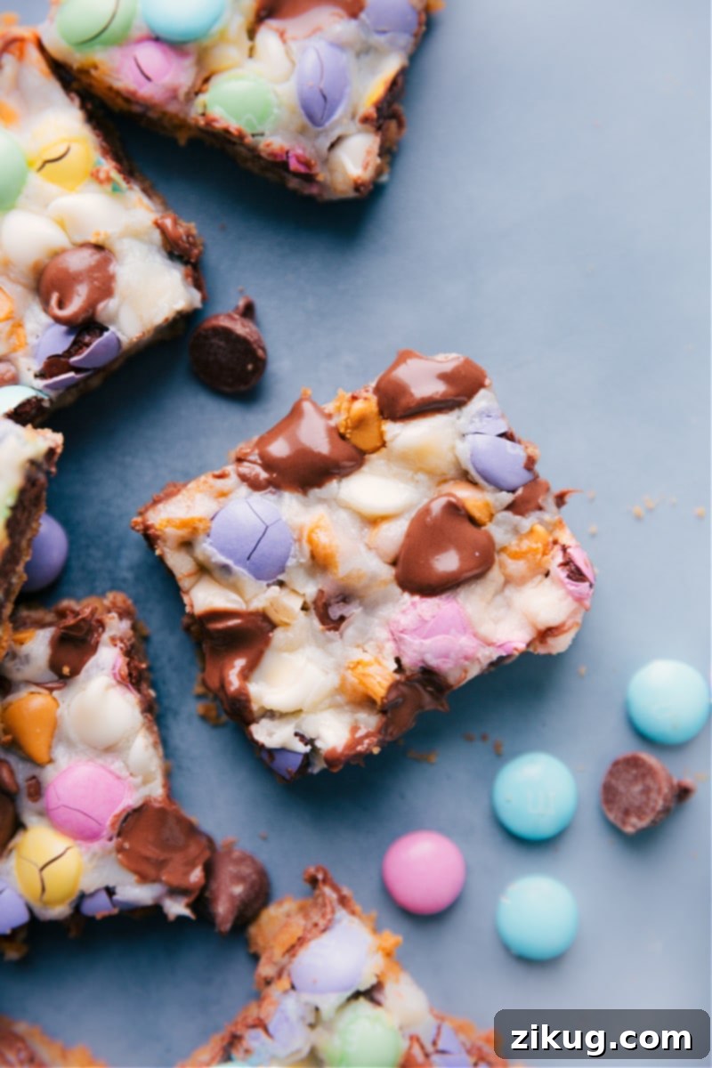 Loaded Magic Bars with graham cracker crust, chocolate chips, M&M's, and oats A full tray of ultimate Magic Bars, showcasing a thick graham cracker crust loaded with chocolate chips, M&M's, and oats, ready to be enjoyed.