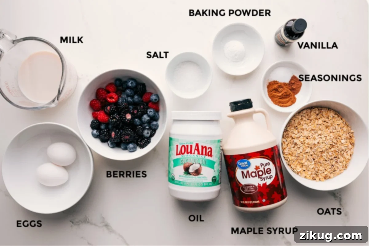 Ingredients in this recipe prepped out for easy assembly including the milk, eggs, berries, salt, oil, maple syrup, oats, seasonings, vanilla, and baking powder.