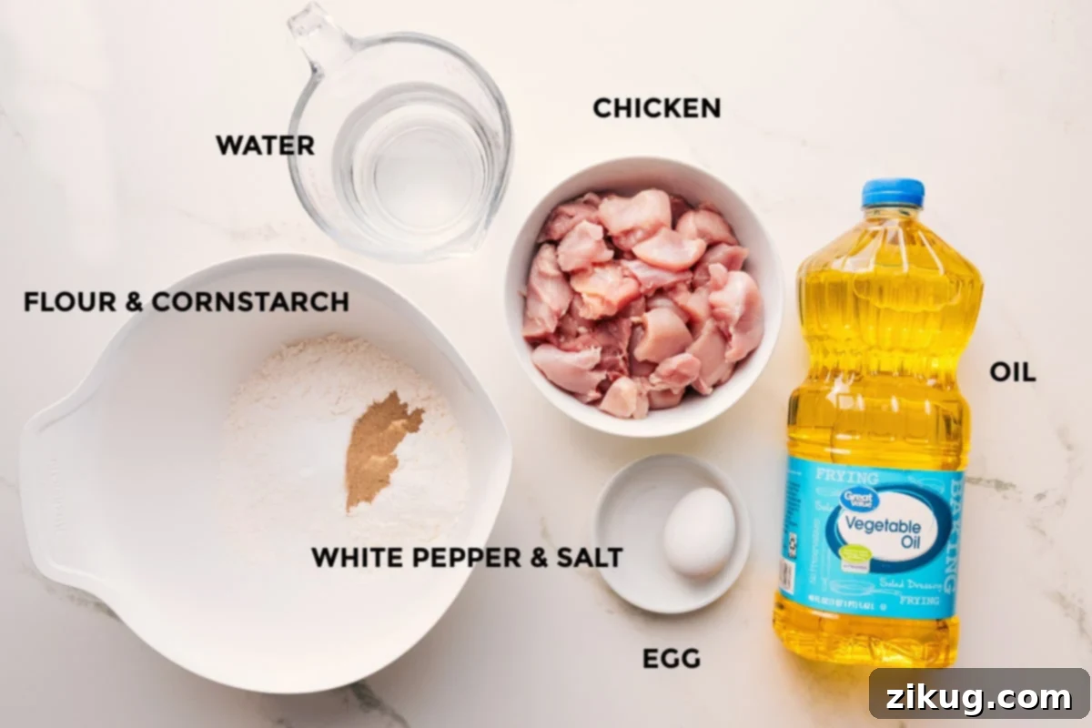 Korean Fried Chicken: A Flavor Explosion 4 Korean chicken recipe ingredients prepped out for easy assembly including the flour, cornstarch, water, chicken, white pepper, salt, egg, and oil.