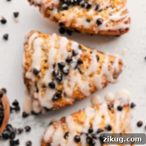 A beautifully glazed chocolate chip scone with a sprinkle of chocolate chips on top.
